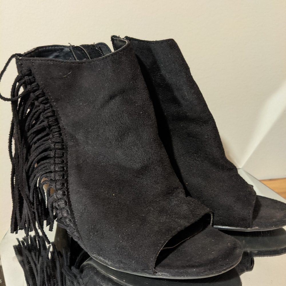 Black heeled boots with fringe.